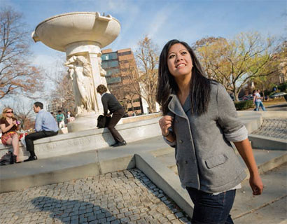 Roselle Bajet walks in a plaza with a fountain