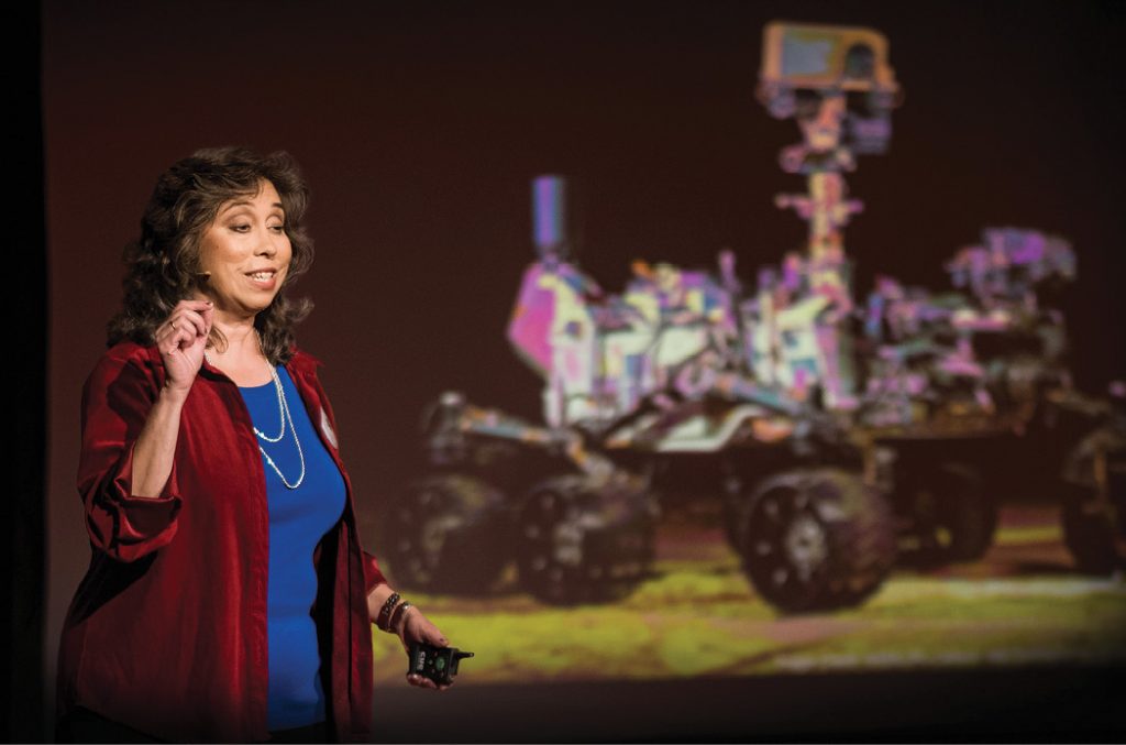 Cox gives a lecture in front of a picture of the Mars rover.