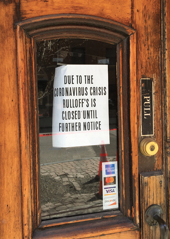 The sign in the window of the wooden door reads: Due to the Coronavirus crisis, Ruloff's is closed until further notice.